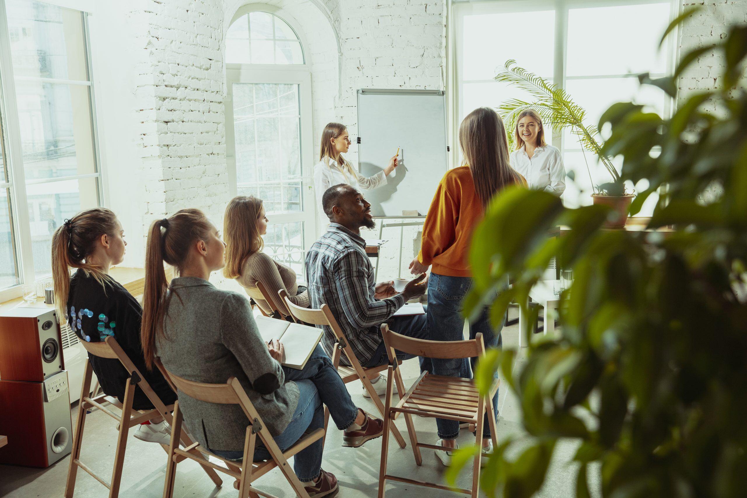 A diverse team in a bright room attending a content marketing workshop, with a female presenter leading a collaborative discussion