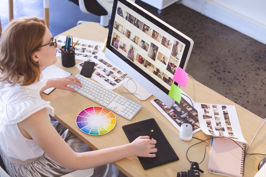 A female graphic designer working on a project and using a colour wheel to help her-1-1