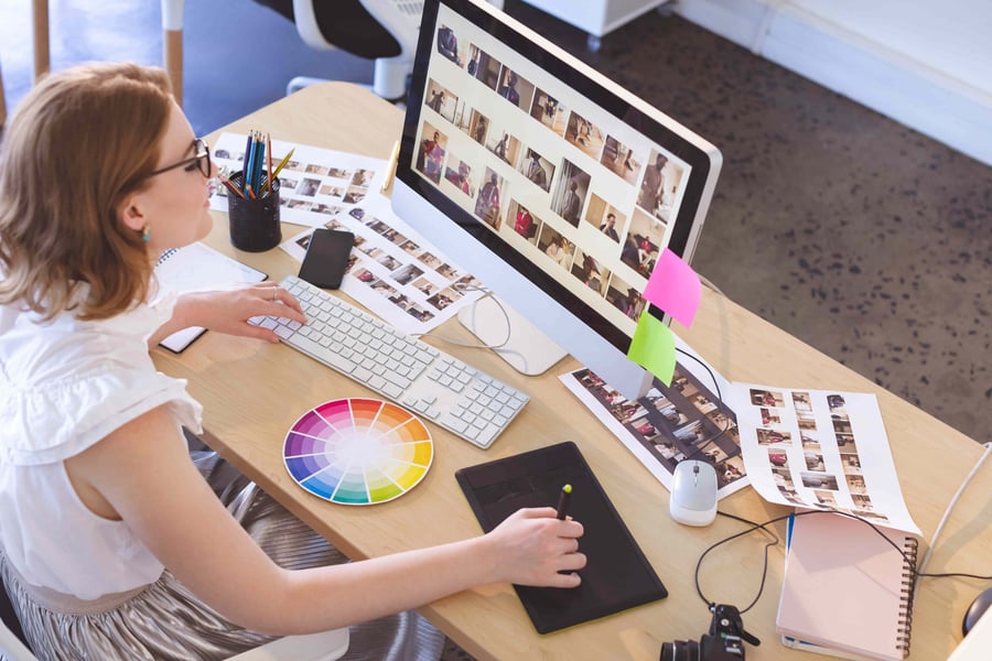 A female graphic designer working on a project and using a colour wheel to help her.