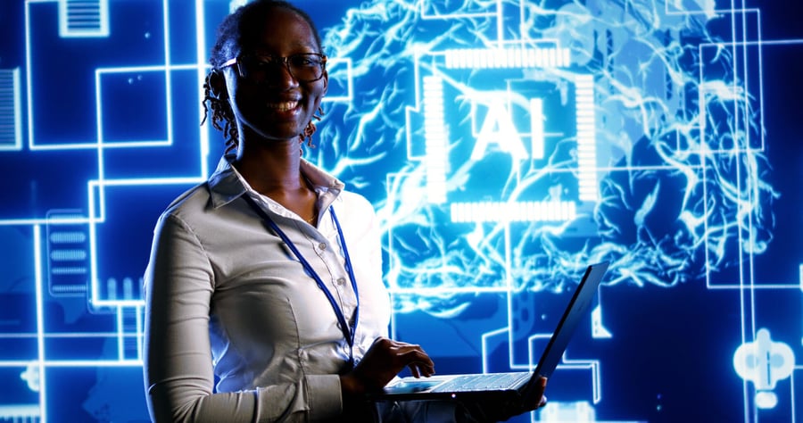 A person smiling while working on a laptop with a bright, futuristic AI graphic in the background.