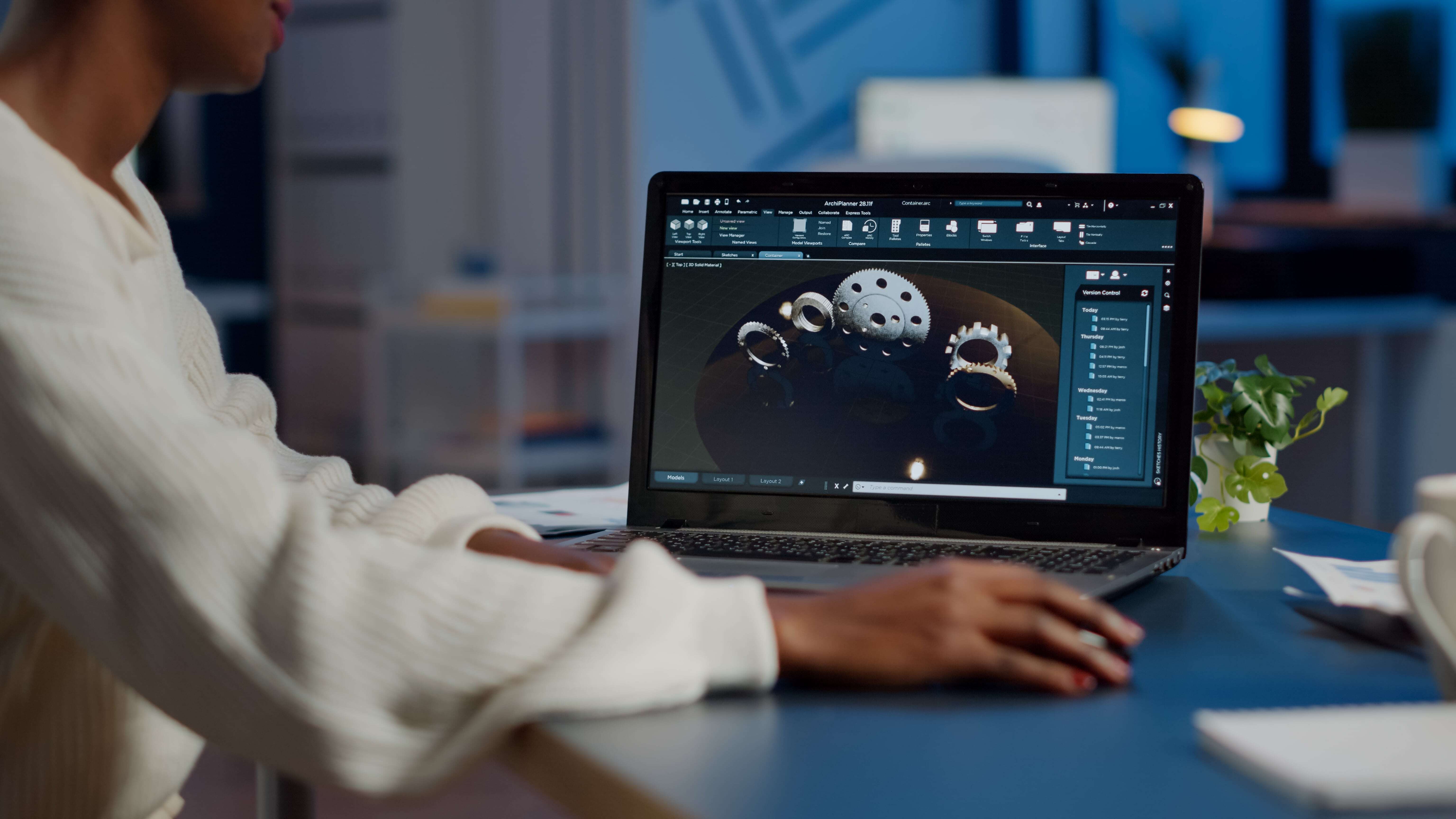 African woman engineer working on a 3D design project on her laptop in a modern office.