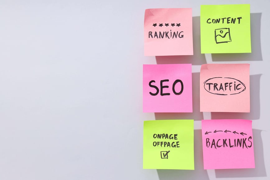Sticky notes on a whiteboard read SEO, Ranking, Content, Traffic, Onpage Offpage, and Backlinks, showing digital marketing concepts.-