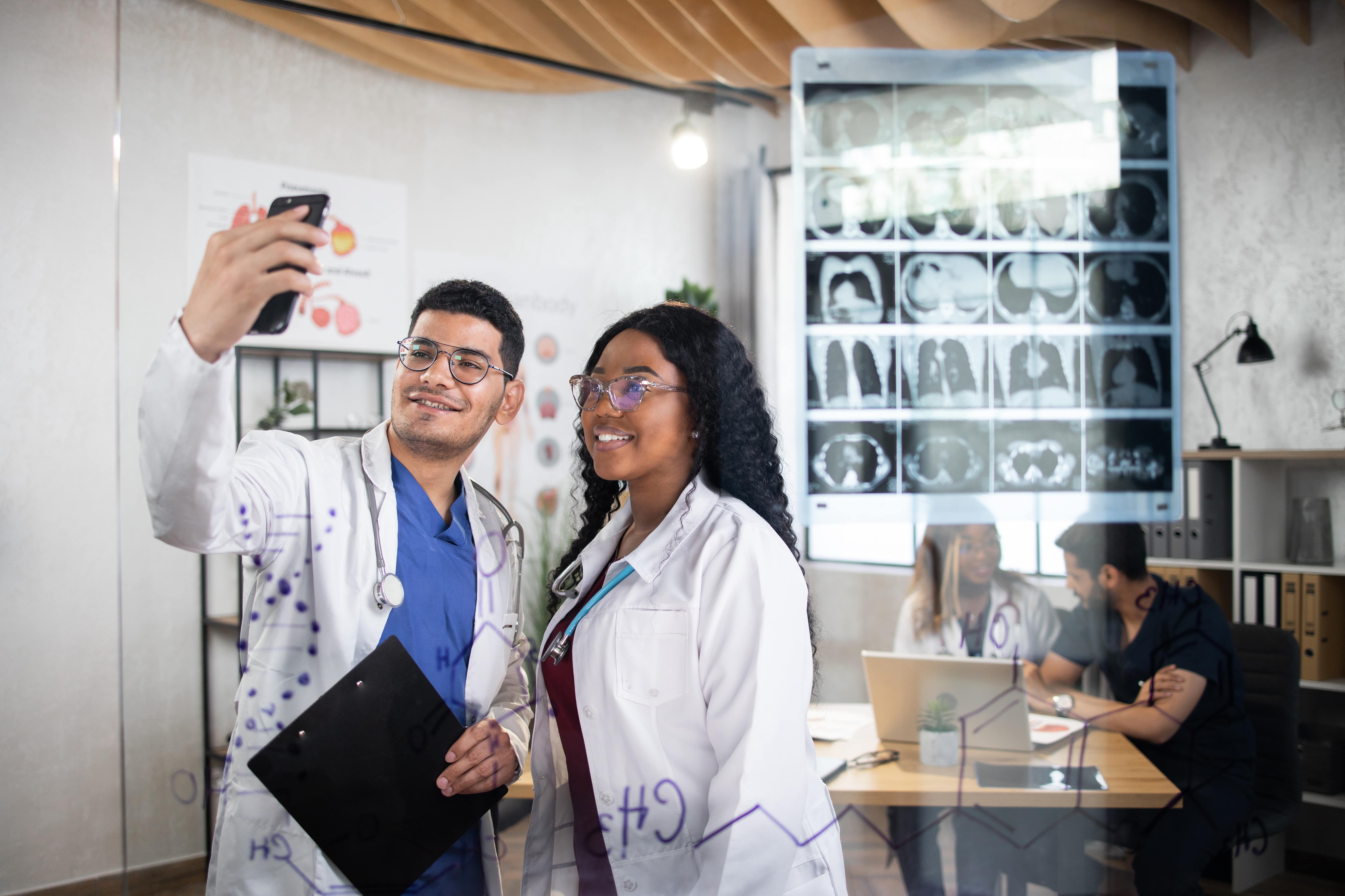 Two doctors taking a social media photo in a lab