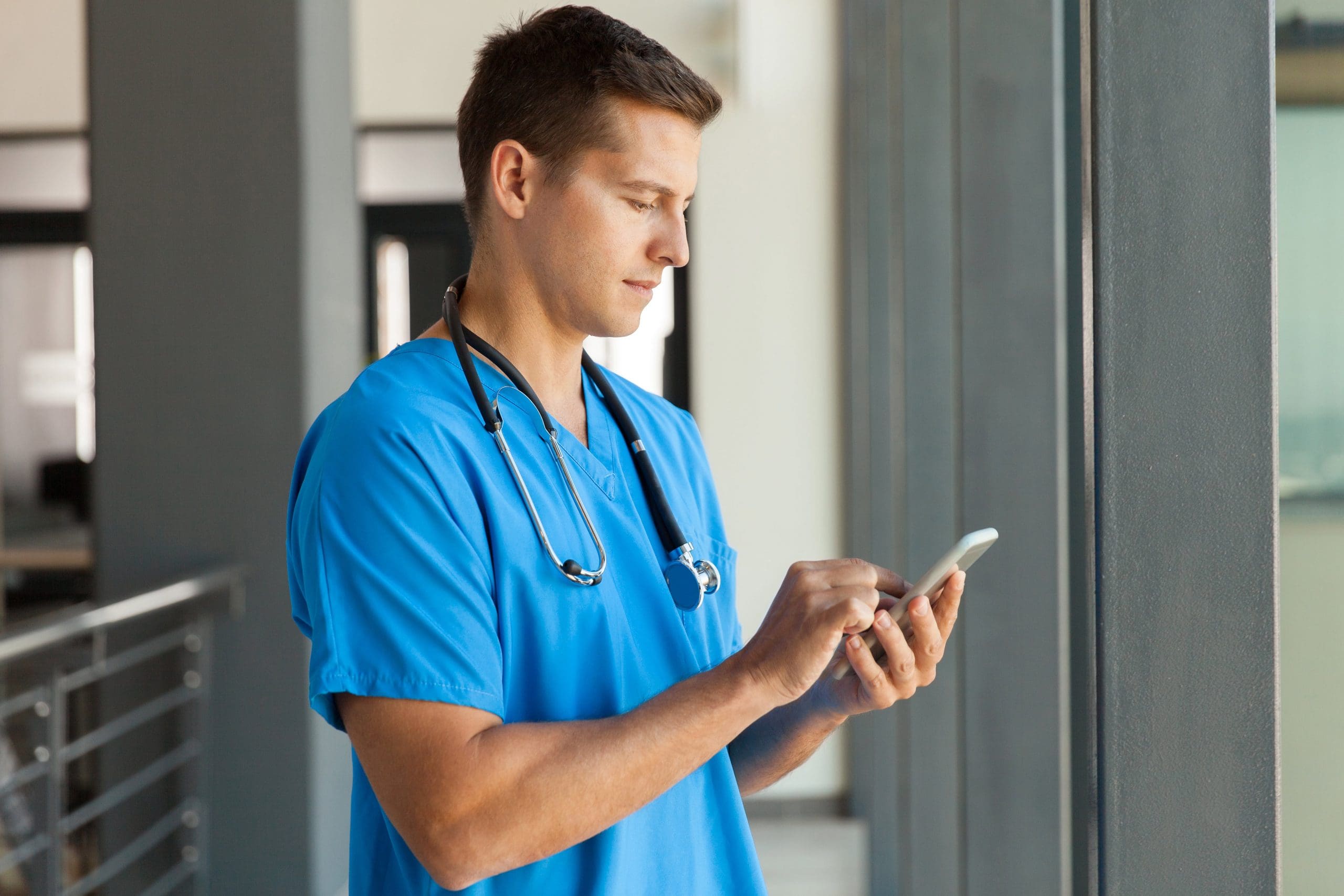 A healthcare professional on his smartphone searching for the best medical device websites.