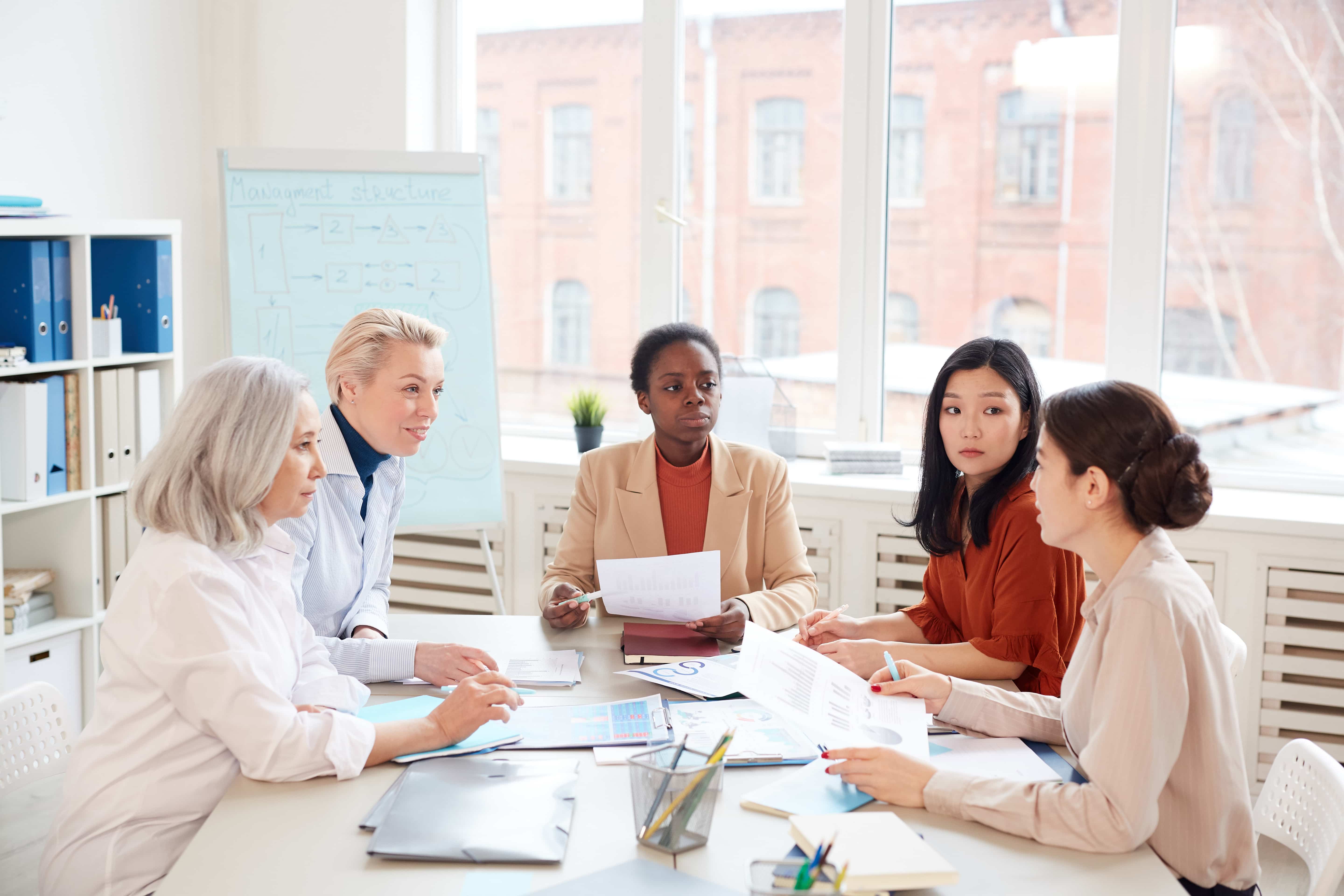 A diverse team of professionals in a meeting room discussing the 