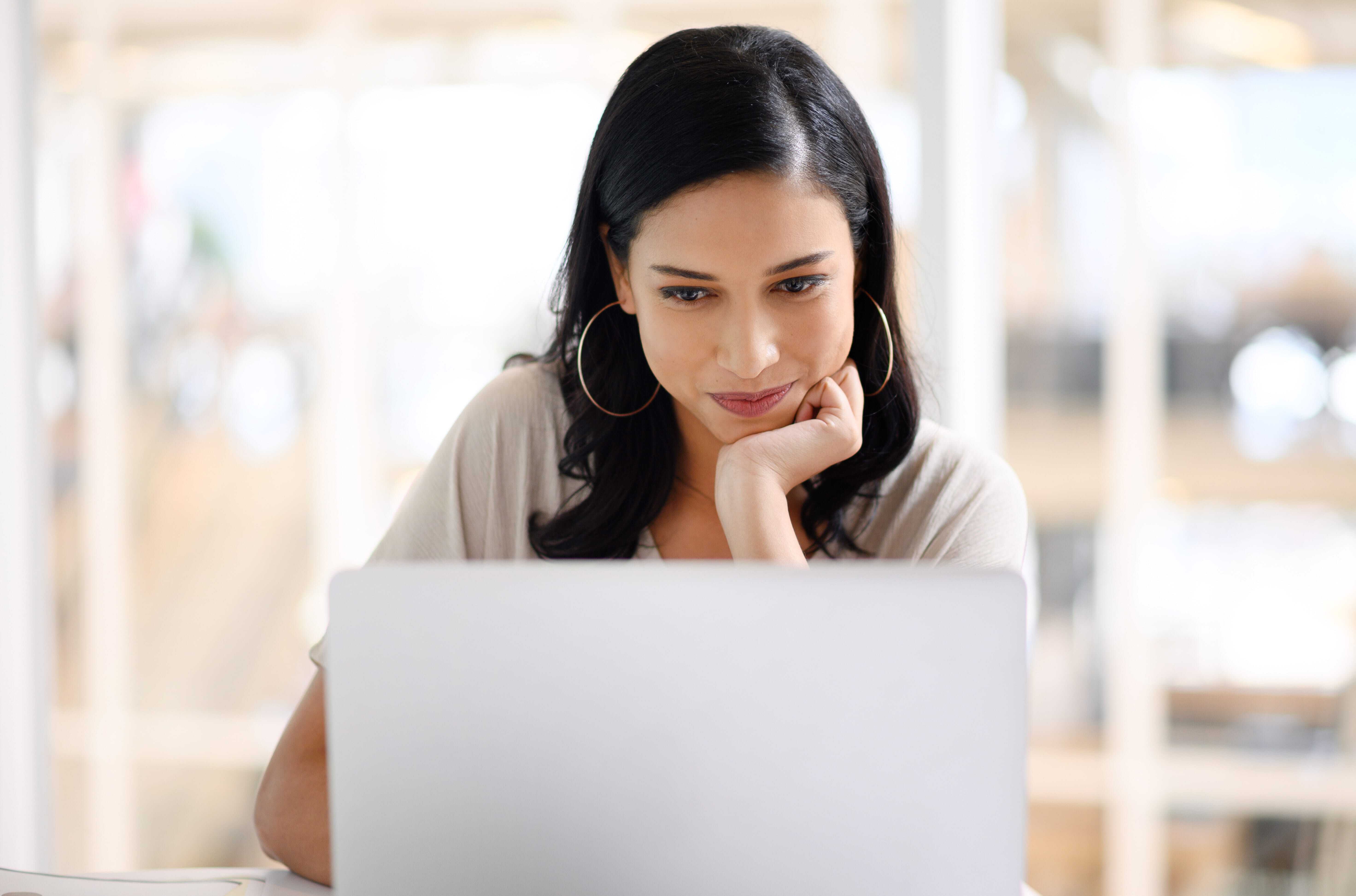 A woman looking at her emails on her computer.