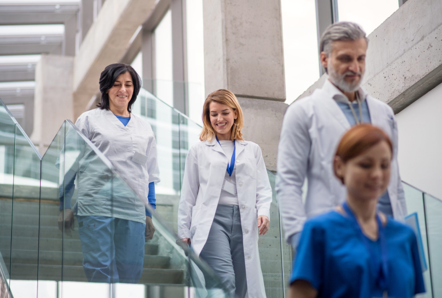 Doctors in white coats walking down the hallways of a hospital. 