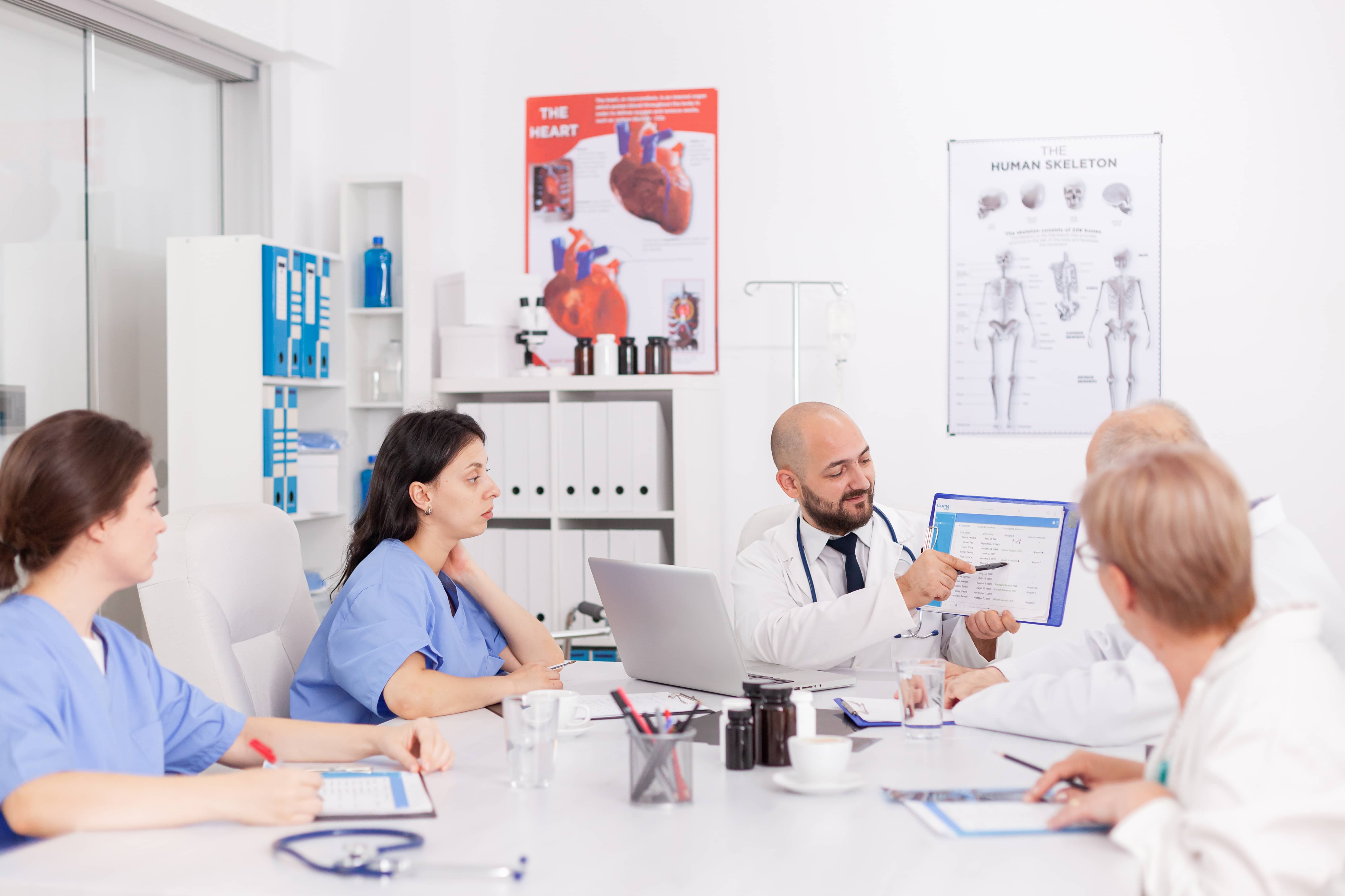 A Medical team reviewing a piece of work together in order to streamline their workload. 