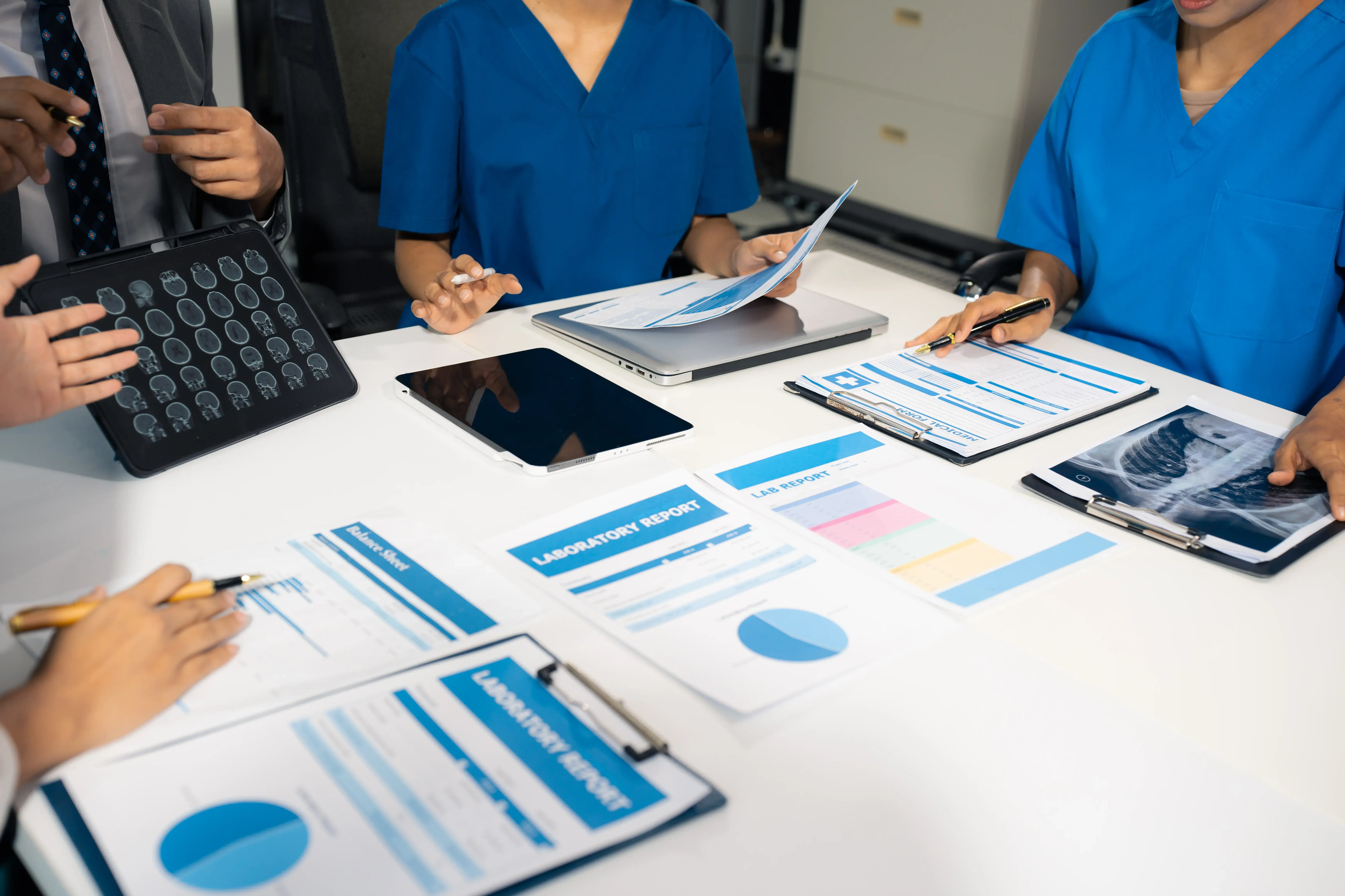 Medical device sales team reviewing printed out reports from CRM